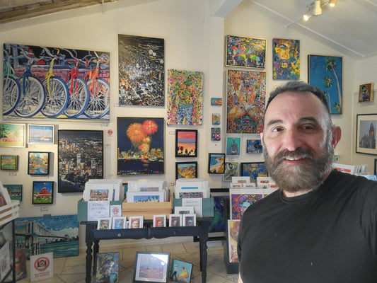 RD Riccoboni in his studio with original paintings on the walls and prints displayed on the tables